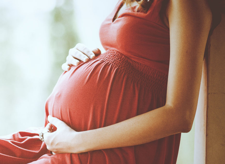 kobieta z ciążowym brzuchem w czerwonej sukience